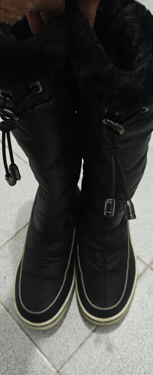 Botas de caña alta negras acolchadas con detalles de piel sintética en la parte superior. Ideales para el invierno, con cordones ajustables y suela blanca.