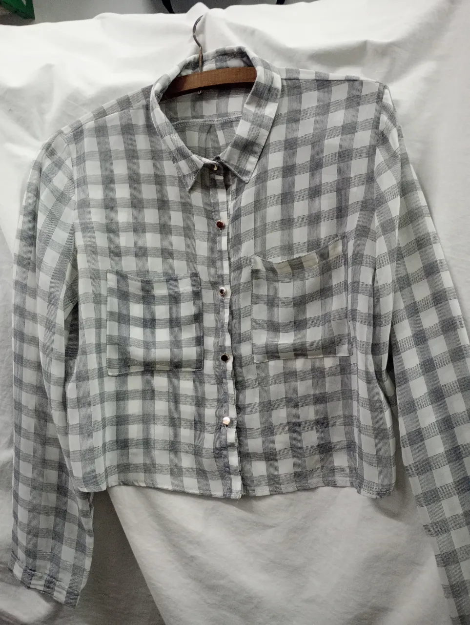 Camisa a cuadros manga larga con dos bolsillos en el frente y botones.