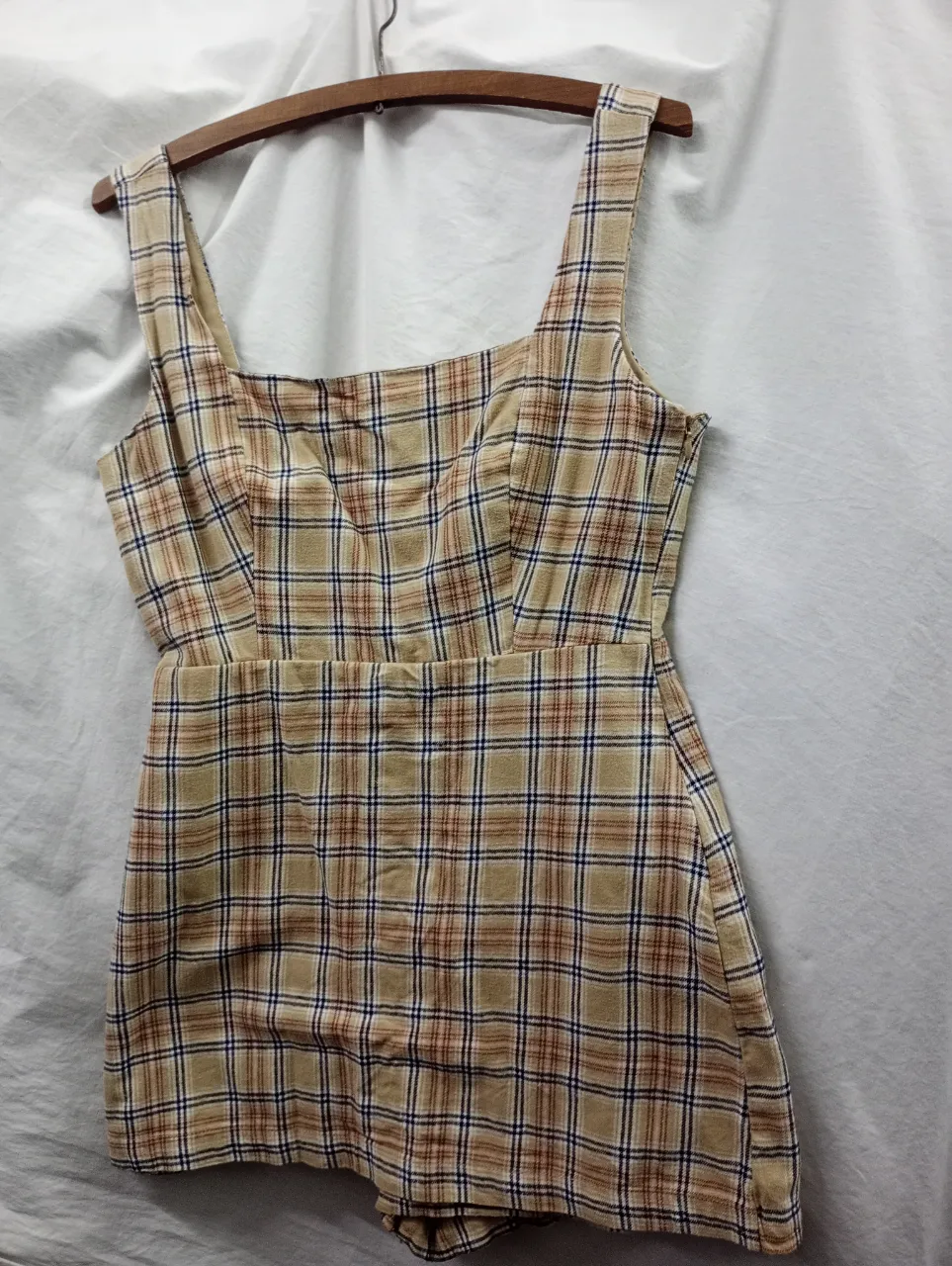 Mono corto de tela a cuadros con breteles anchos y escote cuadrado. Cintura marcada y short con pinzas.