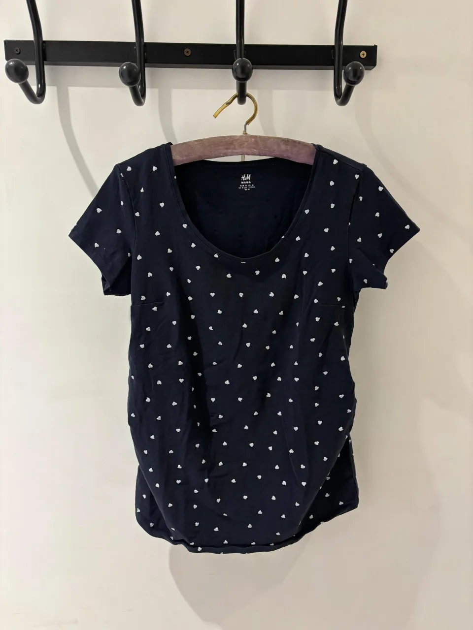 Remera azul marino con estampa de corazones blancos, ideal para embarazadas. Su diseño cómodo y tierno la hace perfecta para el día a día.