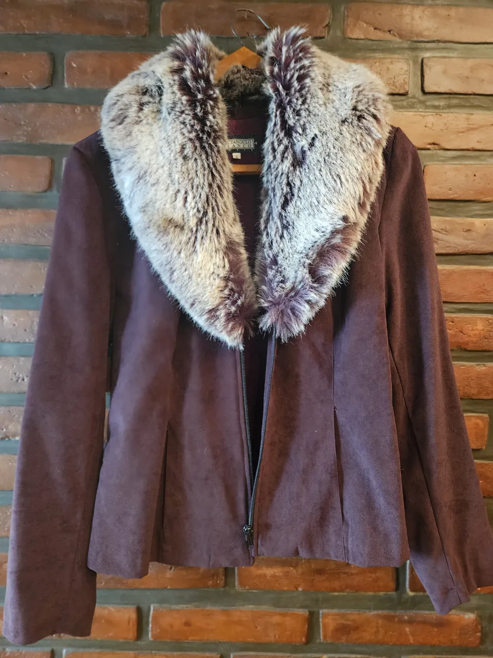 Campera corta de gamuza color bordó con cuello de piel sintética desmontable. Cierre al frente.