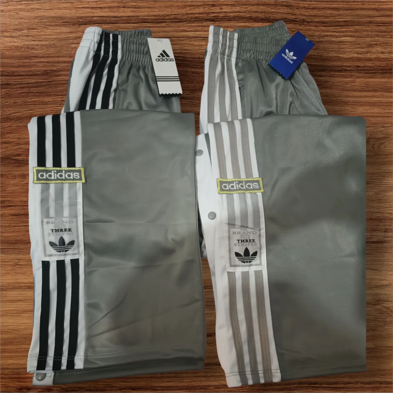 Short deportivo Adidas gris con detalles blancos y las icónicas tres tiras. Ideal para entrenar o para un look casual y cómodo.