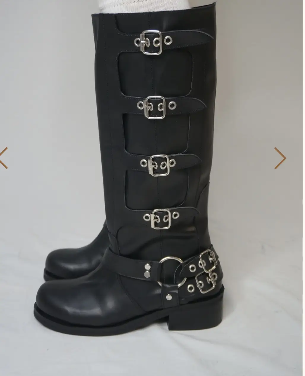 Botas altas negras con múltiples hebillas y detalles metálicos. Estilo rocker y audaz, ideales para un look impactante.