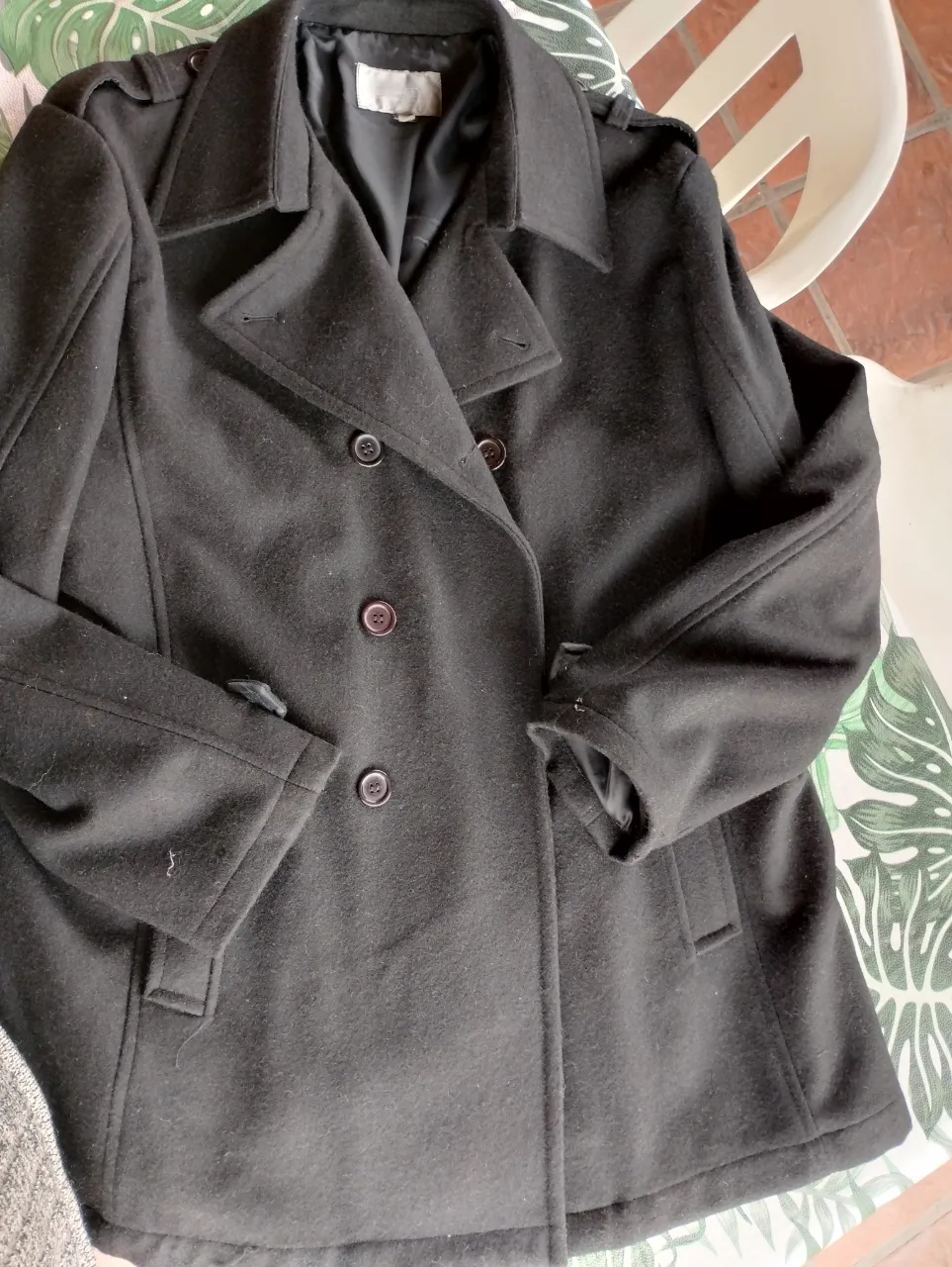 Sobretodo de paño negro para hombre, estilo clásico con botones y solapas. Ideal para el invierno.