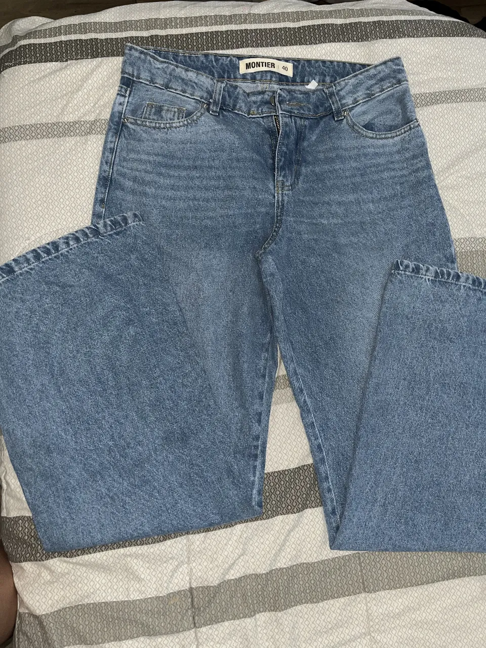 Jeans rectos de mujer, tiro alto, color azul claro, con etiqueta de la marca Montier y talle 40.