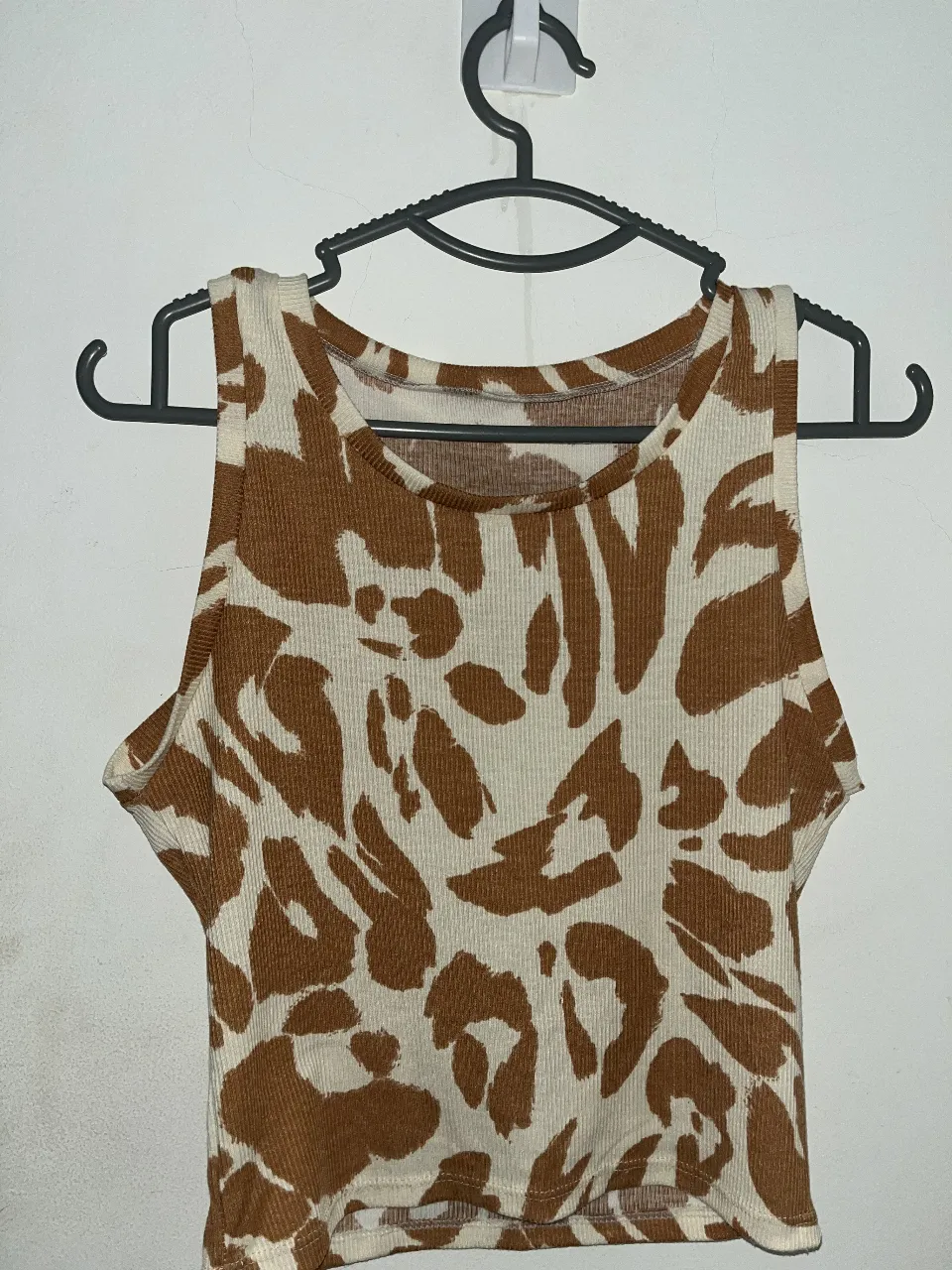 Top sin mangas con estampado de leopardo en tonos marrones y blanco. Ideal para un look casual y moderno.