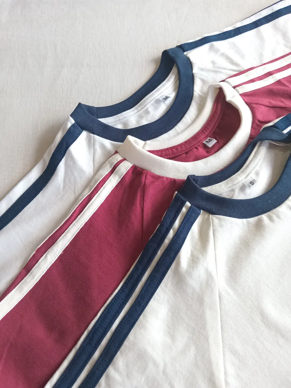 Remera manga corta estilo retro con cuello y mangas a contratono. Diseño clásico con franjas en las mangas y cuello redondo. Ideal para un look casual y cómodo.