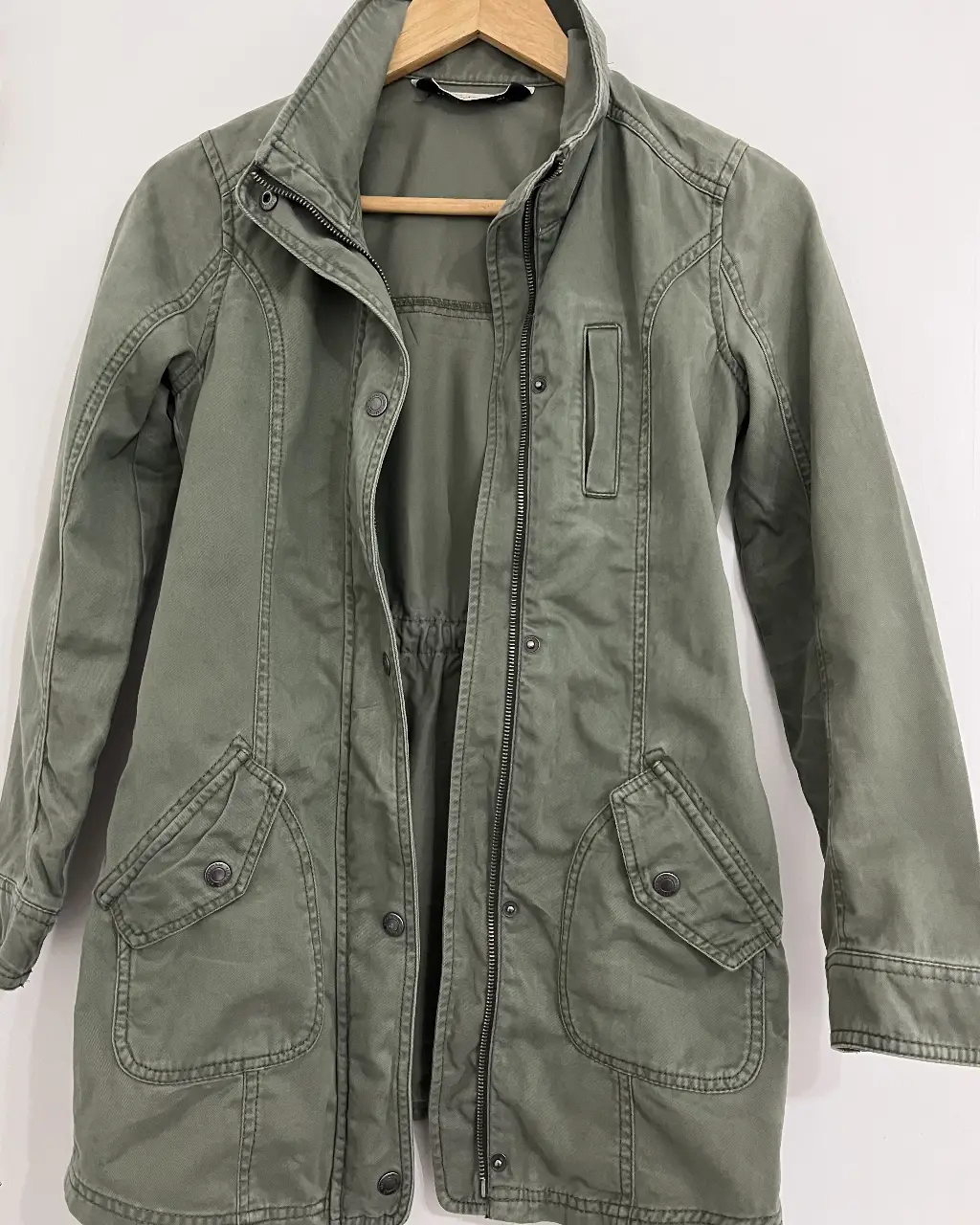 Campera verde militar de tela resistente, con cierre frontal y bolsillos amplios. Ideal para un look casual y cómodo.