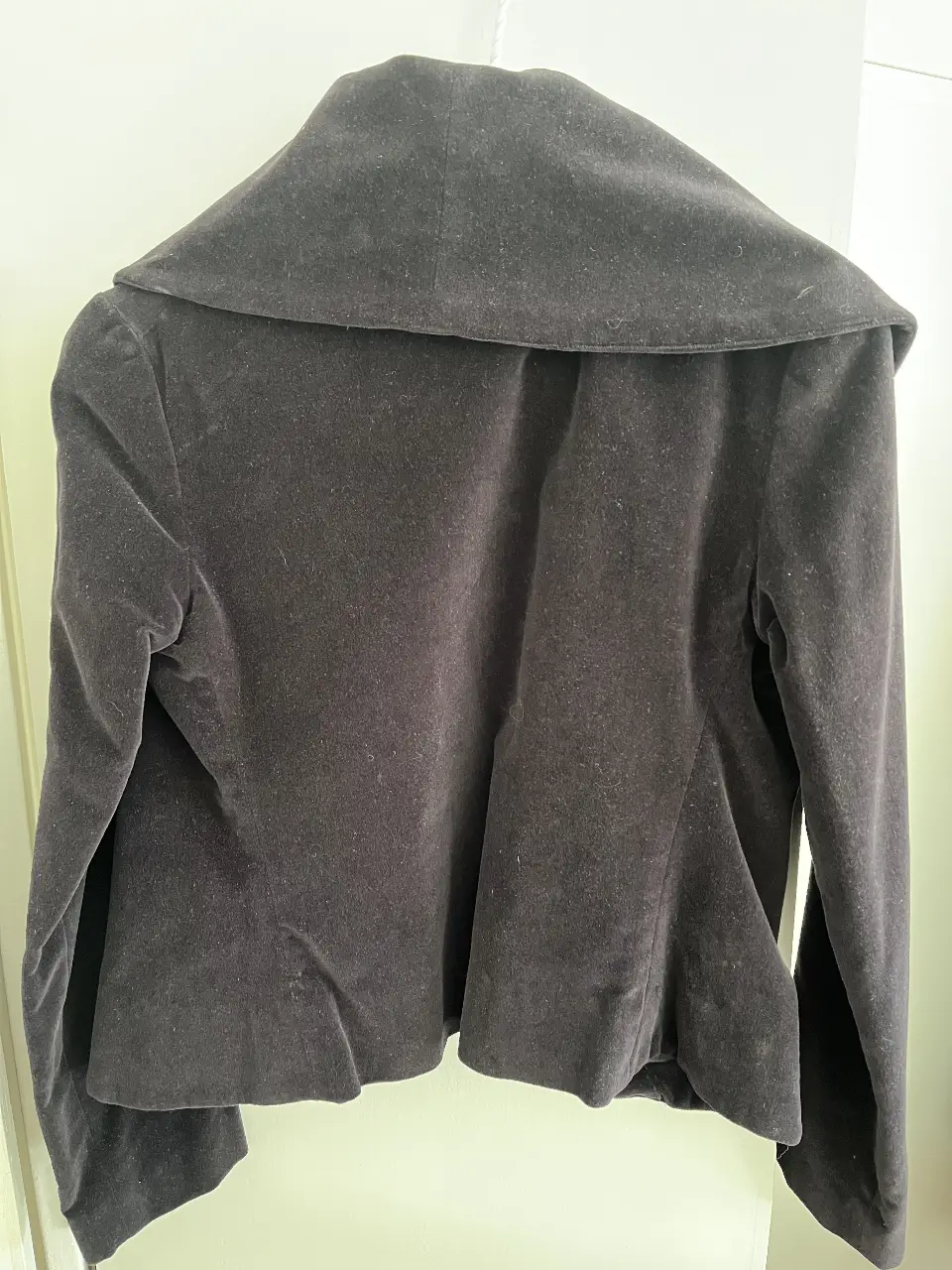 Chaqueta de terciopelo negro, con cuello solapa y dos botones. Ideal para un look elegante y sofisticado.