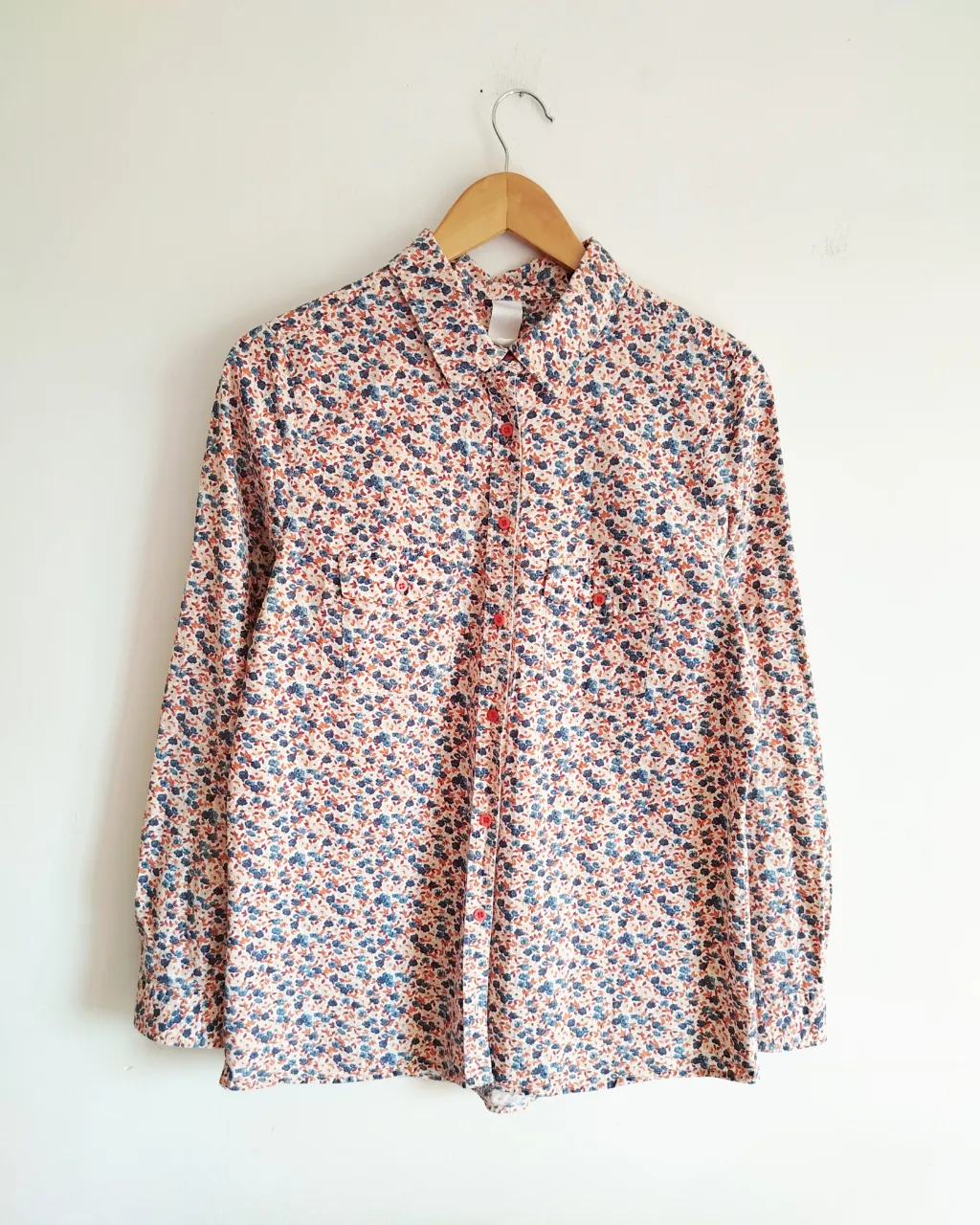 Camisa de manga larga con estampa floral en tonos azules, naranjas y rojos sobre fondo blanco. Posee cuello clásico, botones al frente y dos bolsillos en el pecho. Ideal para un look casual y fresco.
Medidas .

Hombros 39cm

Axila a axila 49cm

Sisa 25cm

Largo de mangas 70cm

Largo 69cm