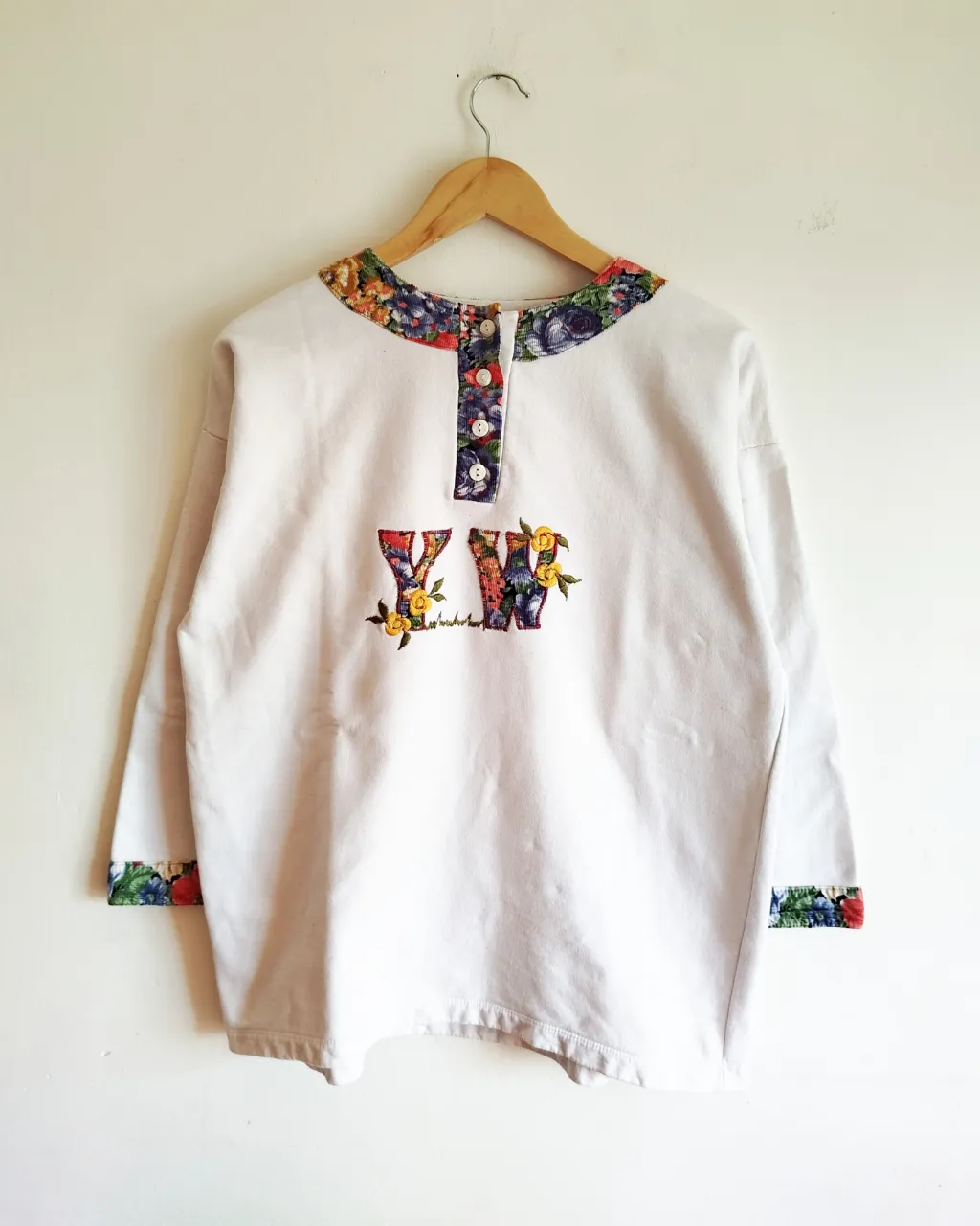 Buzo de algodón, años 90. Recto, color blanco, combinado con detalles en corderoy floreado y. Bordado.

Talle aprox S/M. Chequear medidas

Medidas .

Hombros 57cm ( cae mas abajo del hombro)

Axila a axila 52cm

Sisa 24cm

Largo de mangas (cuello a puño) 63cm

Largo 66cm