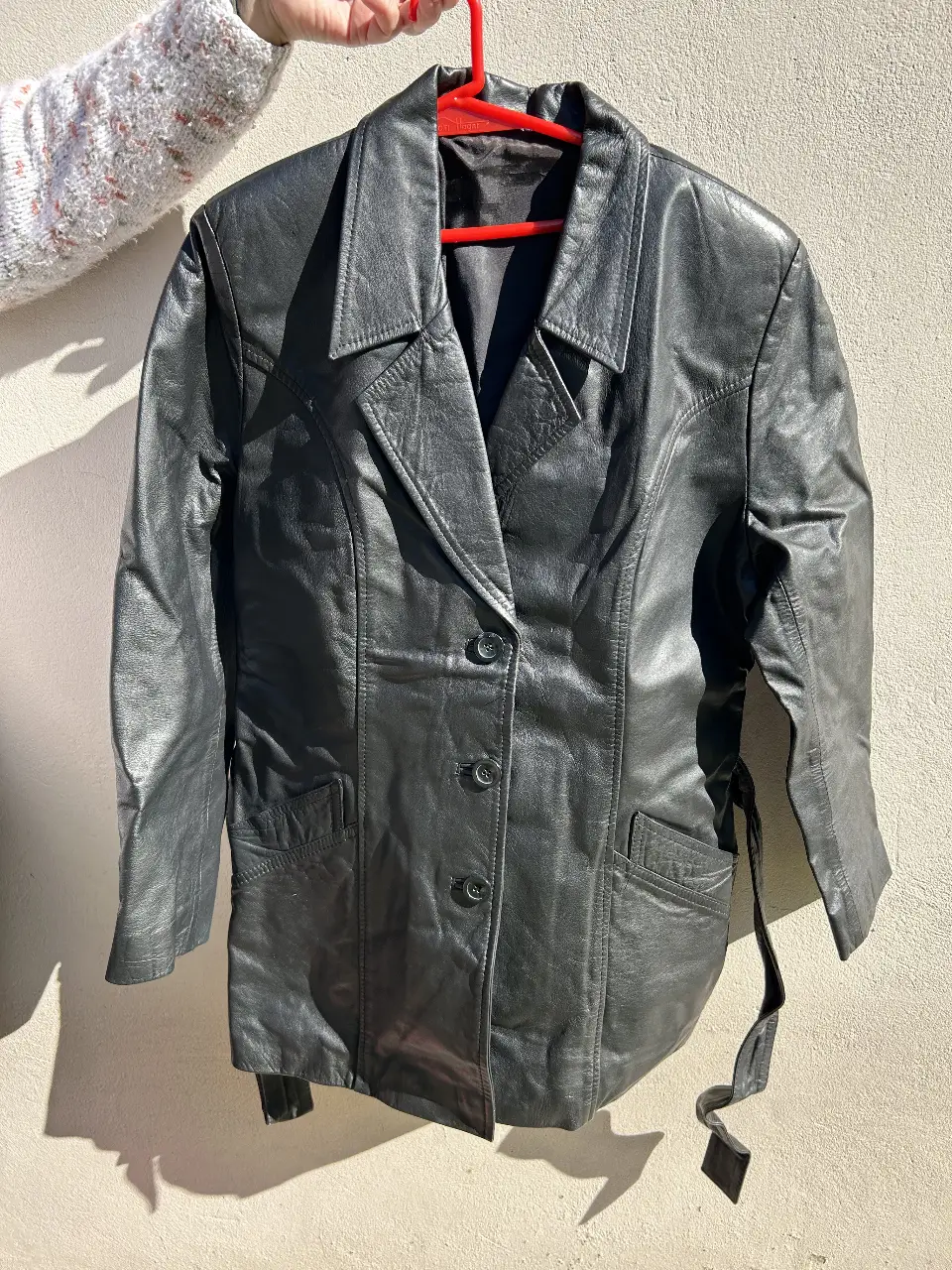 Chaqueta de cuero negra de la marca Poppy's, con botones y cinturón. Ideal para un look rocker o casual.
