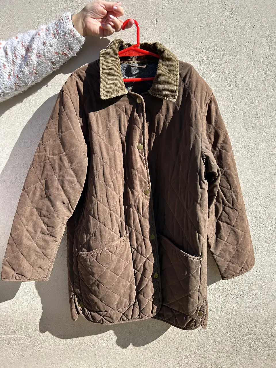 Campera acolchada marrón con cuello de pana y bolsillos. Ideal para un look casual y abrigado.
