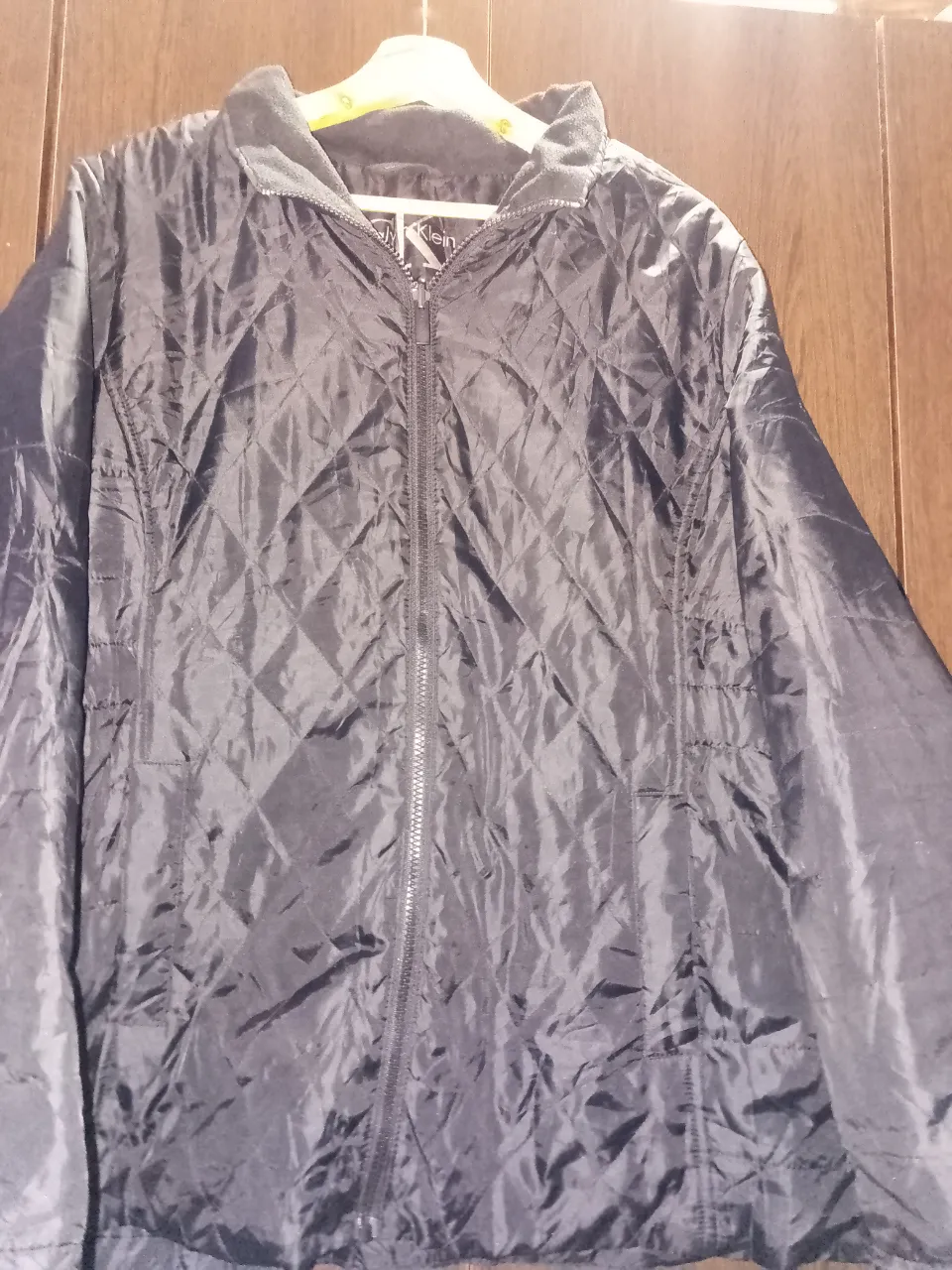 Campera negra acolchada con rombos, cuello redondo y cierre completo. Logo de la marca en la manga.