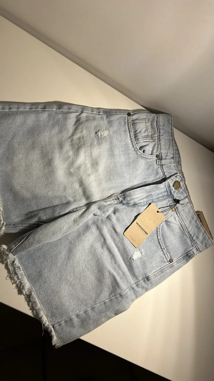 Shorts de jean tiro alto con roturas y detalles desflecados en el ruedo. 