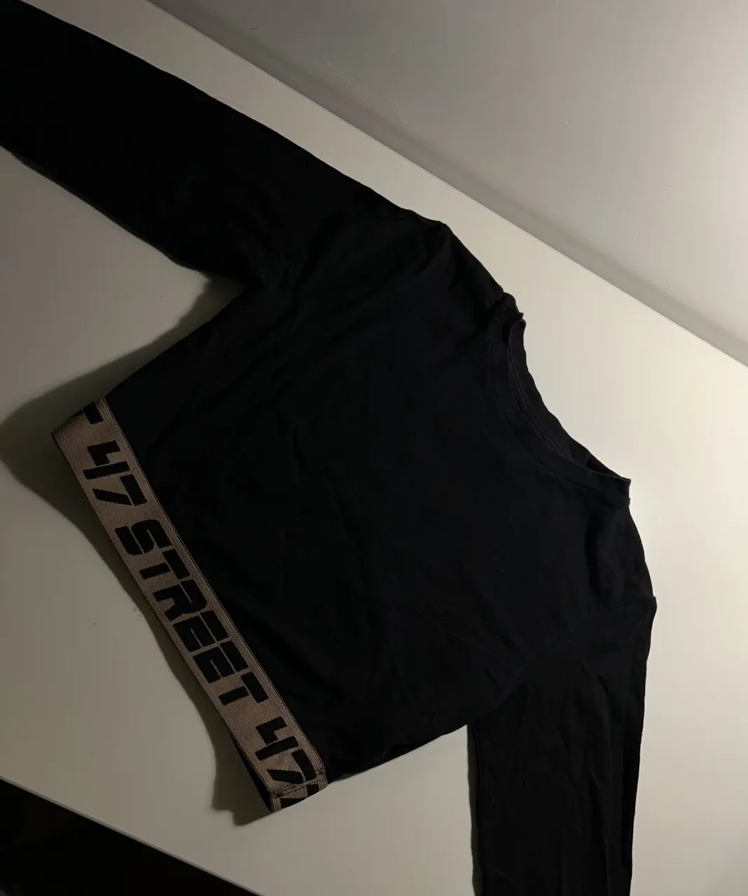 Remera manga larga negra crop con banda inferior estampada 47 STREET.
