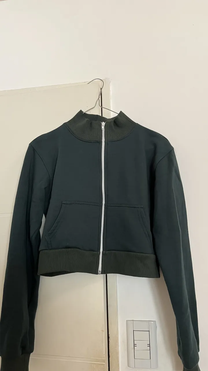Campera deportiva crop con cierre y cuello alto. Ideal para un look casual y moderno.