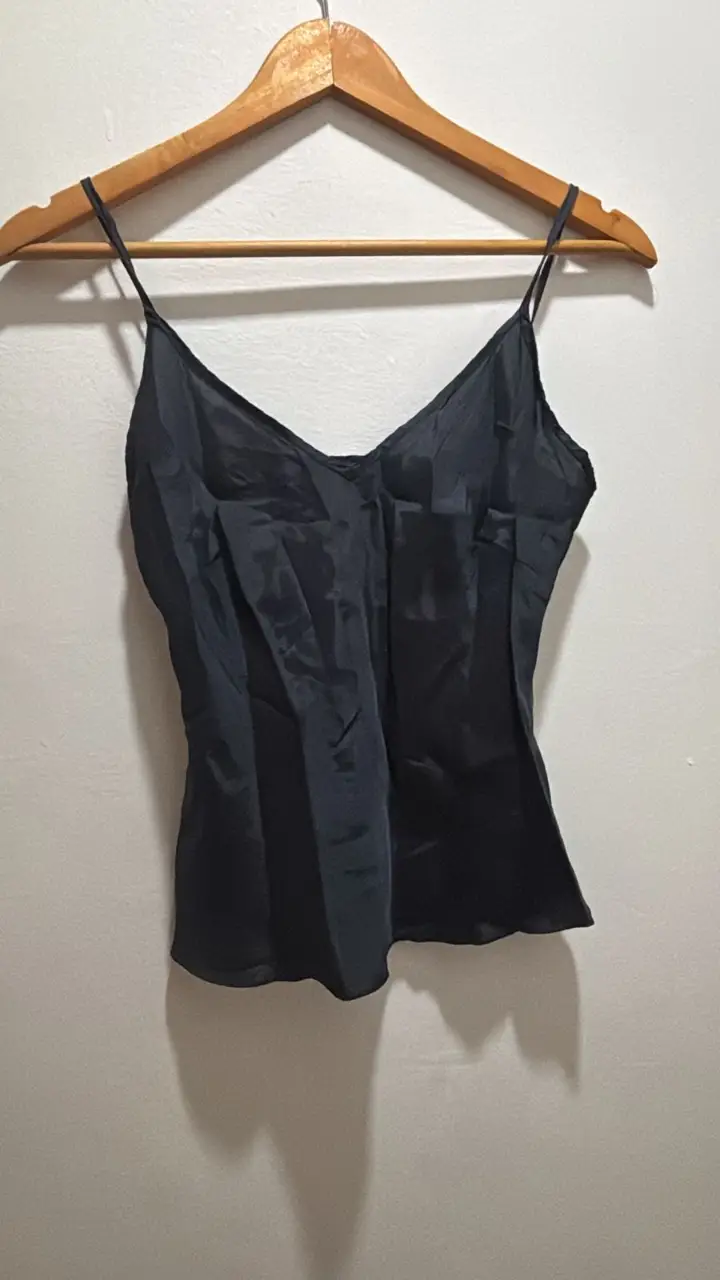 Top negro de seda con tirantes finos y escote en V. Ideal para una salida elegante o para combinar con otras prendas.