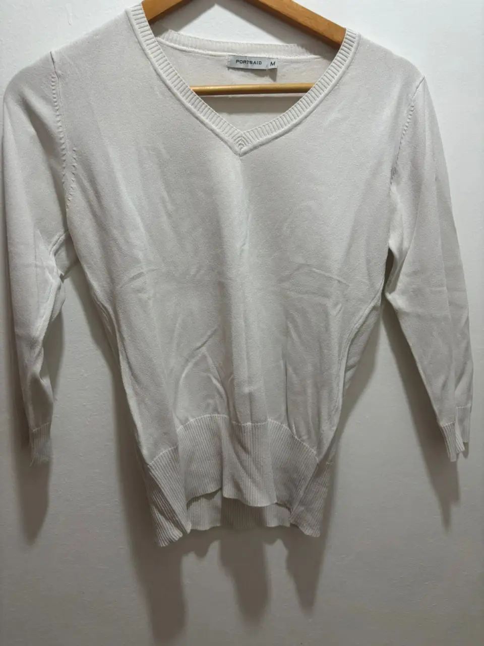 Sweater blanco de mujer con cuello en V y mangas 3/4, ideal para un look casual y elegante. Perfecto para combinar con jeans o pantalones de vestir.