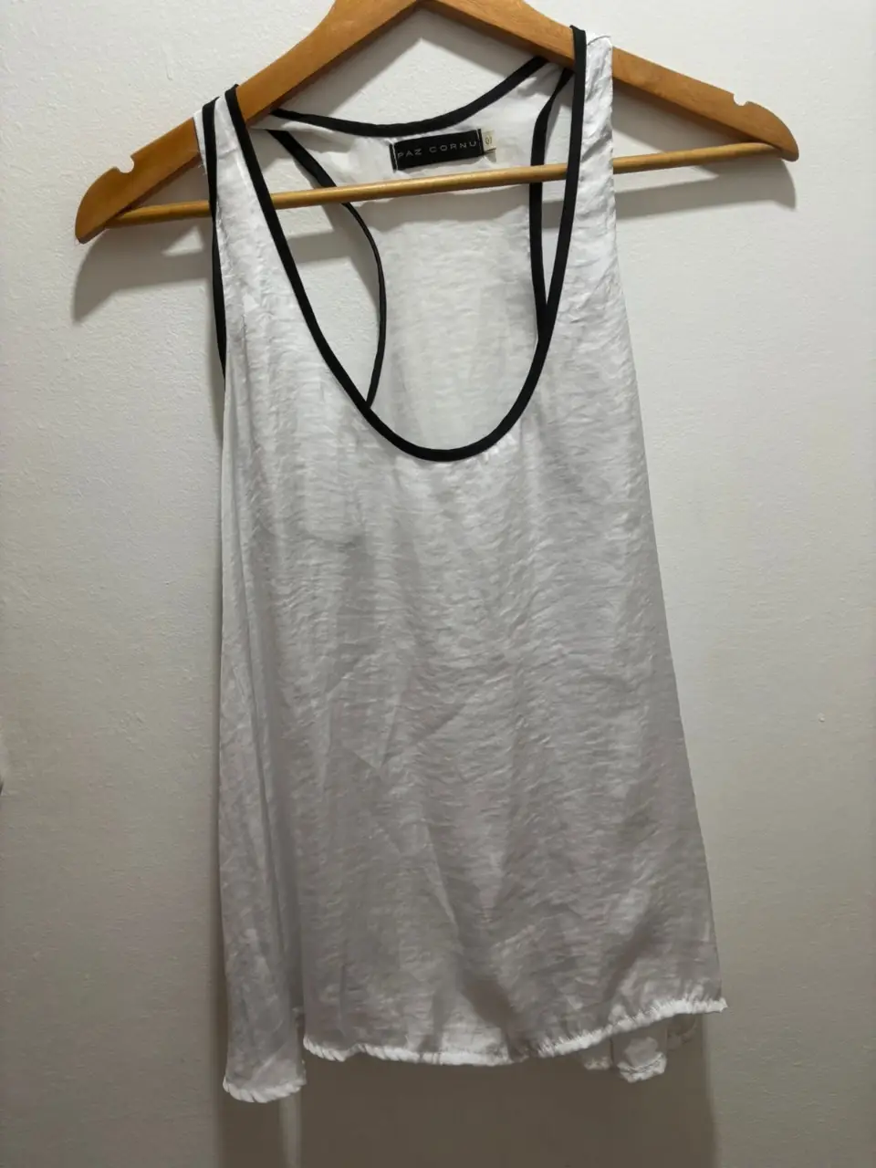 Musculosa blanca con detalles en negro, ideal para un look casual y fresco. Marca Paz Cornu, perfecta para combinar con jeans o shorts.