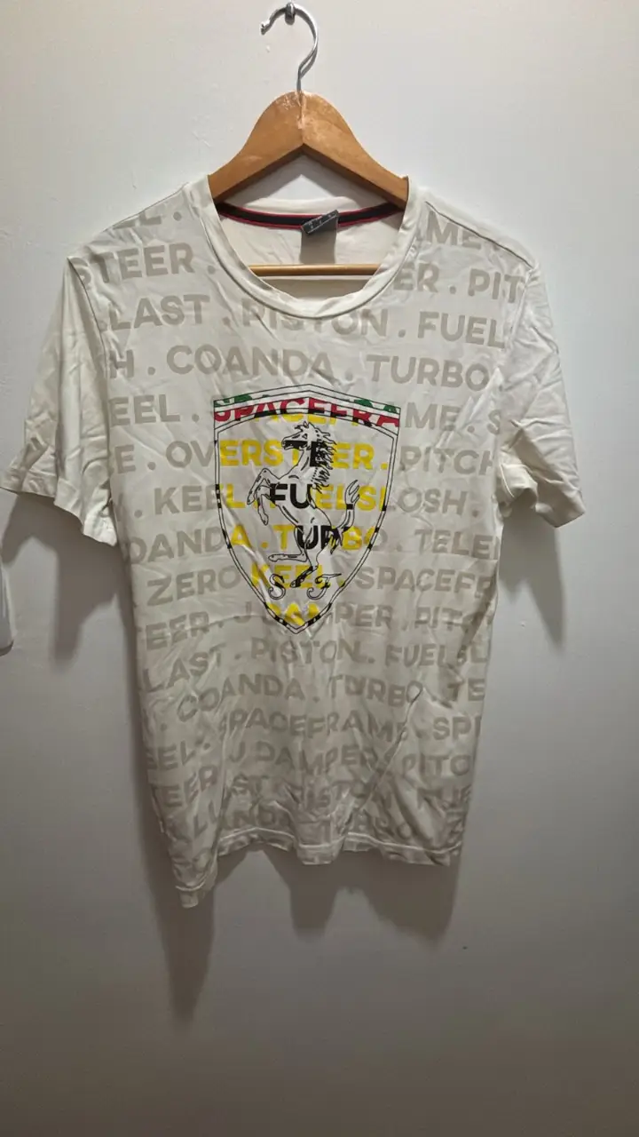 Remera deportiva Puma blanca con estampado de Ferrari. Talle M. Ideal para un look casual y deportivo.