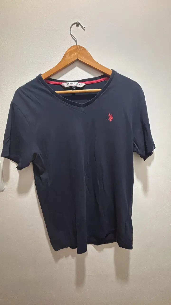 Remera de hombre de color azul marino con cuello en V y logo de la marca U.S. Polo Assn. en rojo. Ideal para un look casual y cómodo.
