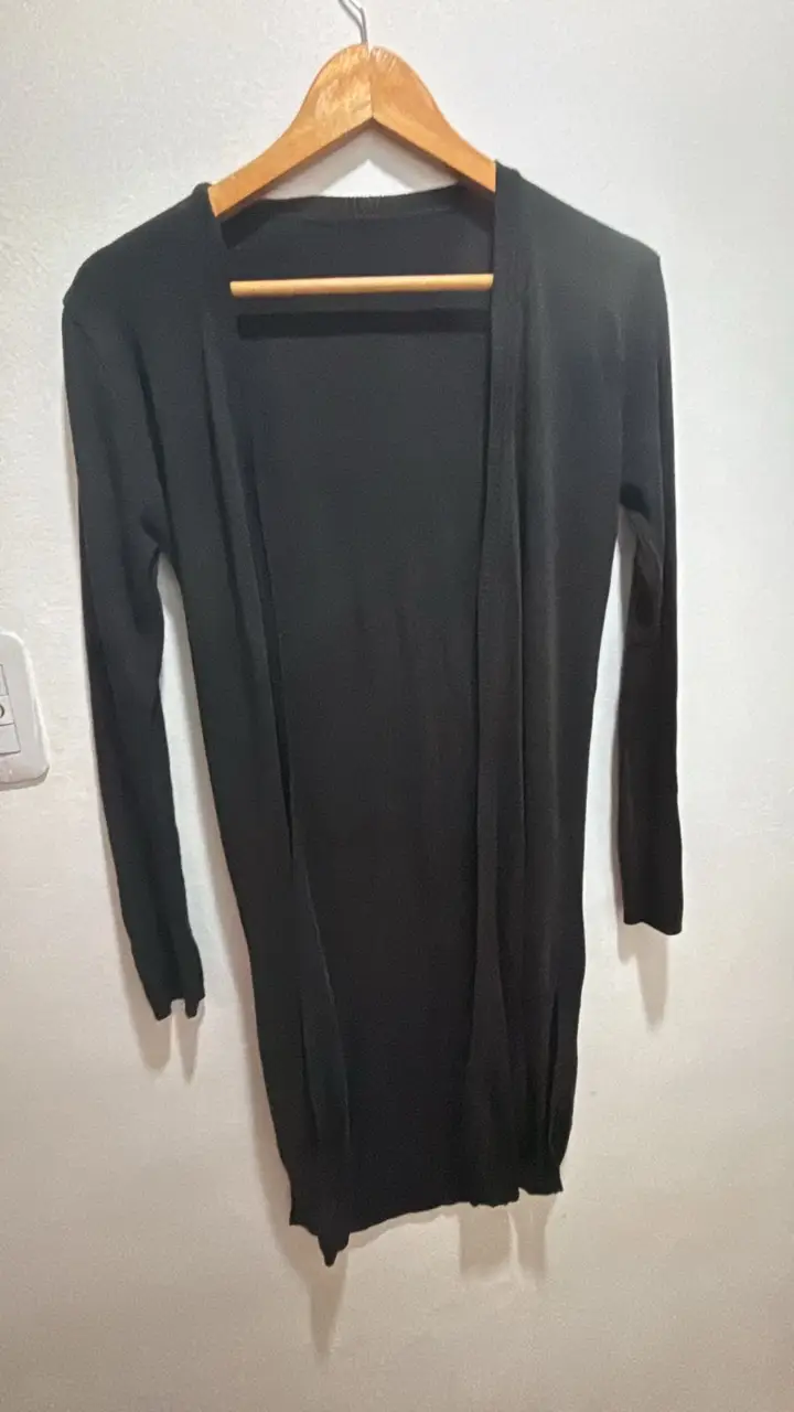 Cardigan largo de mujer, color negro, ideal para usar en cualquier ocasión. Es una prenda versátil y cómoda, perfecta para combinar con diferentes outfits.