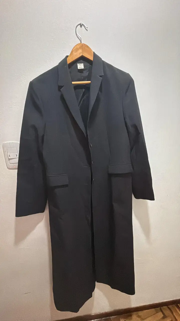 Sobretodo largo de hombre, color negro, con dos bolsillos frontales y un botón para cerrar. Ideal para un look formal o elegante.