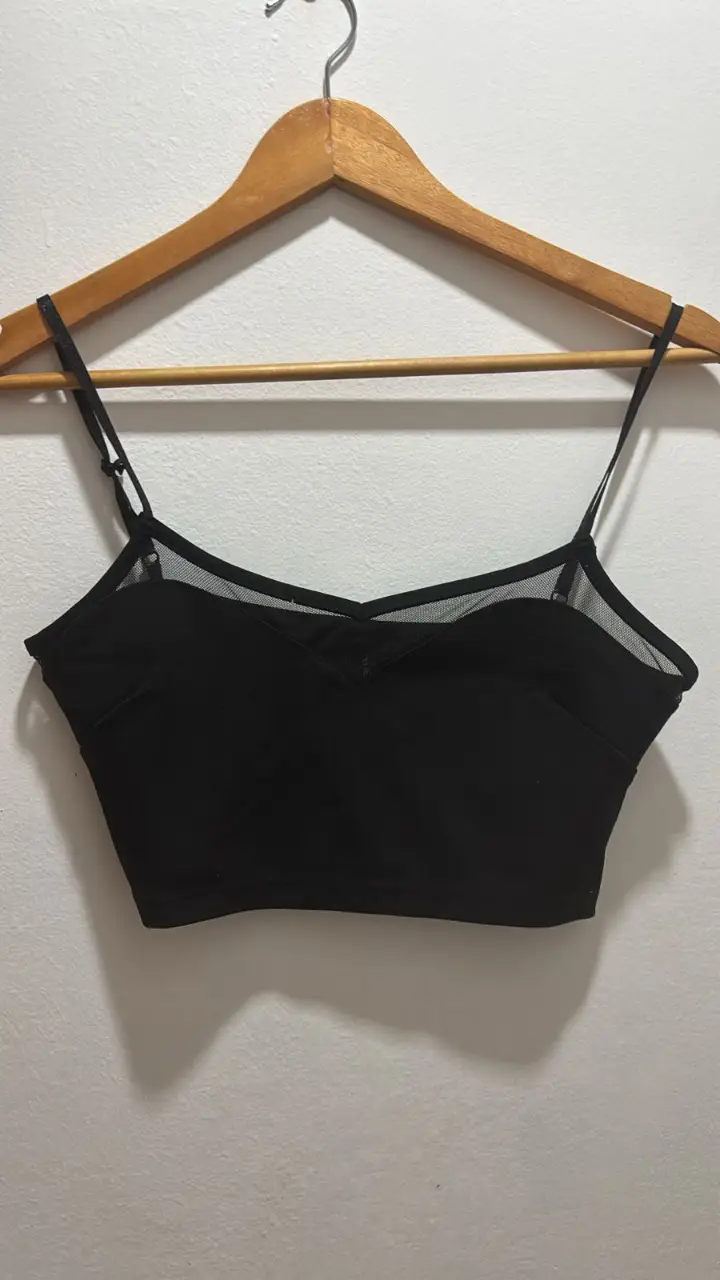 Top negro con breteles finos y detalles de tul. Ideal para combinar con diferentes outfits.