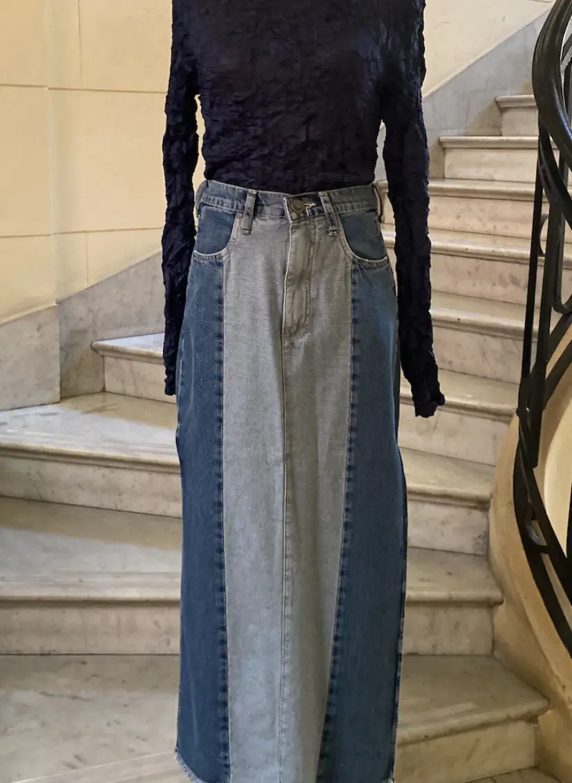Pollera larga de jean con paneles en diferentes tonos de azul y gris. Corte recto con abertura lateral. Marca Rapsodia.