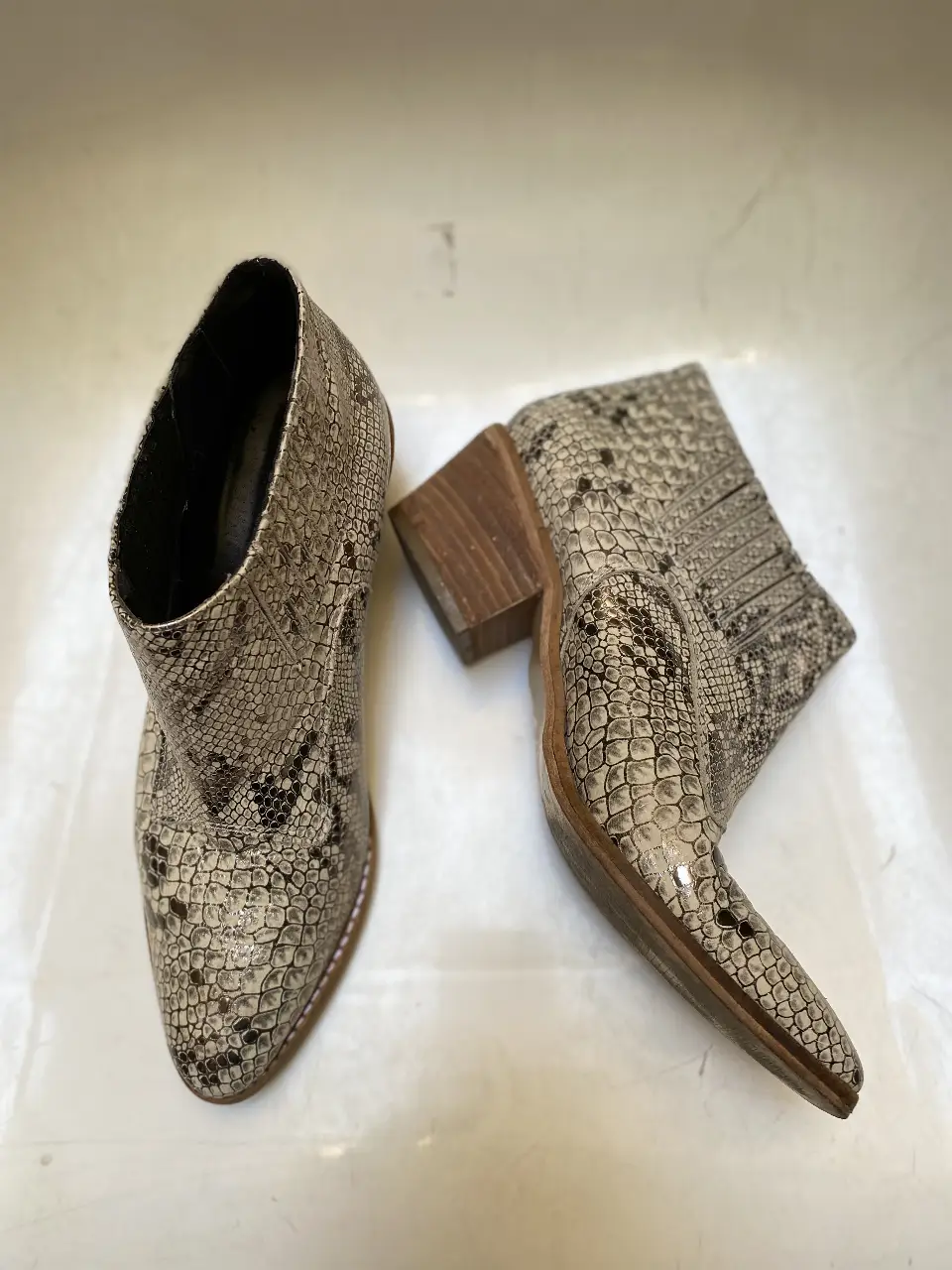 Botines de cuero con estampado de serpiente, taco de madera y punta fina. Ideales para un look moderno y sofisticado.