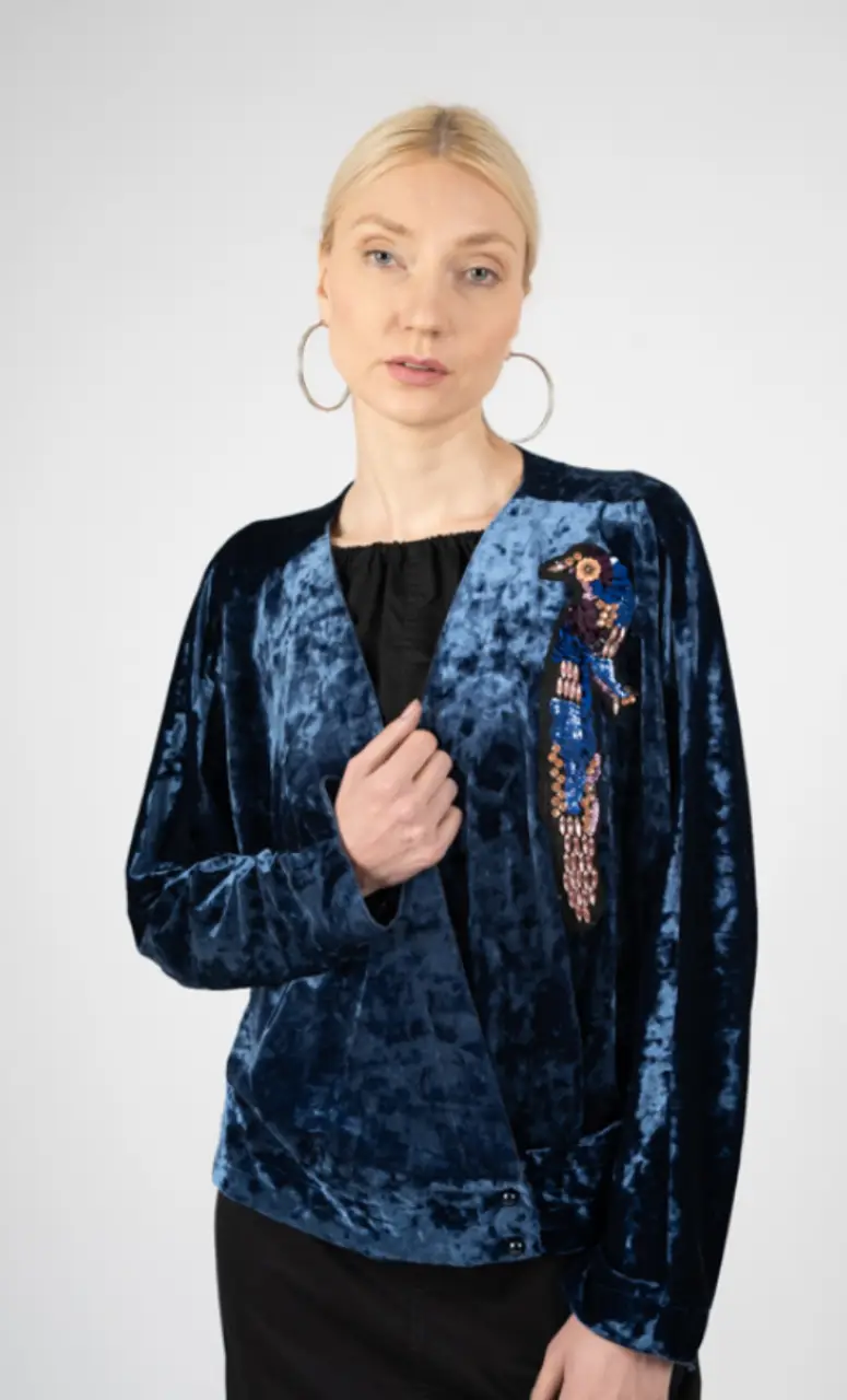 Elegante cardigan de terciopelo azul con un detalle de aplique de pájaro bordado. Ideal para un look sofisticado y con estilo.