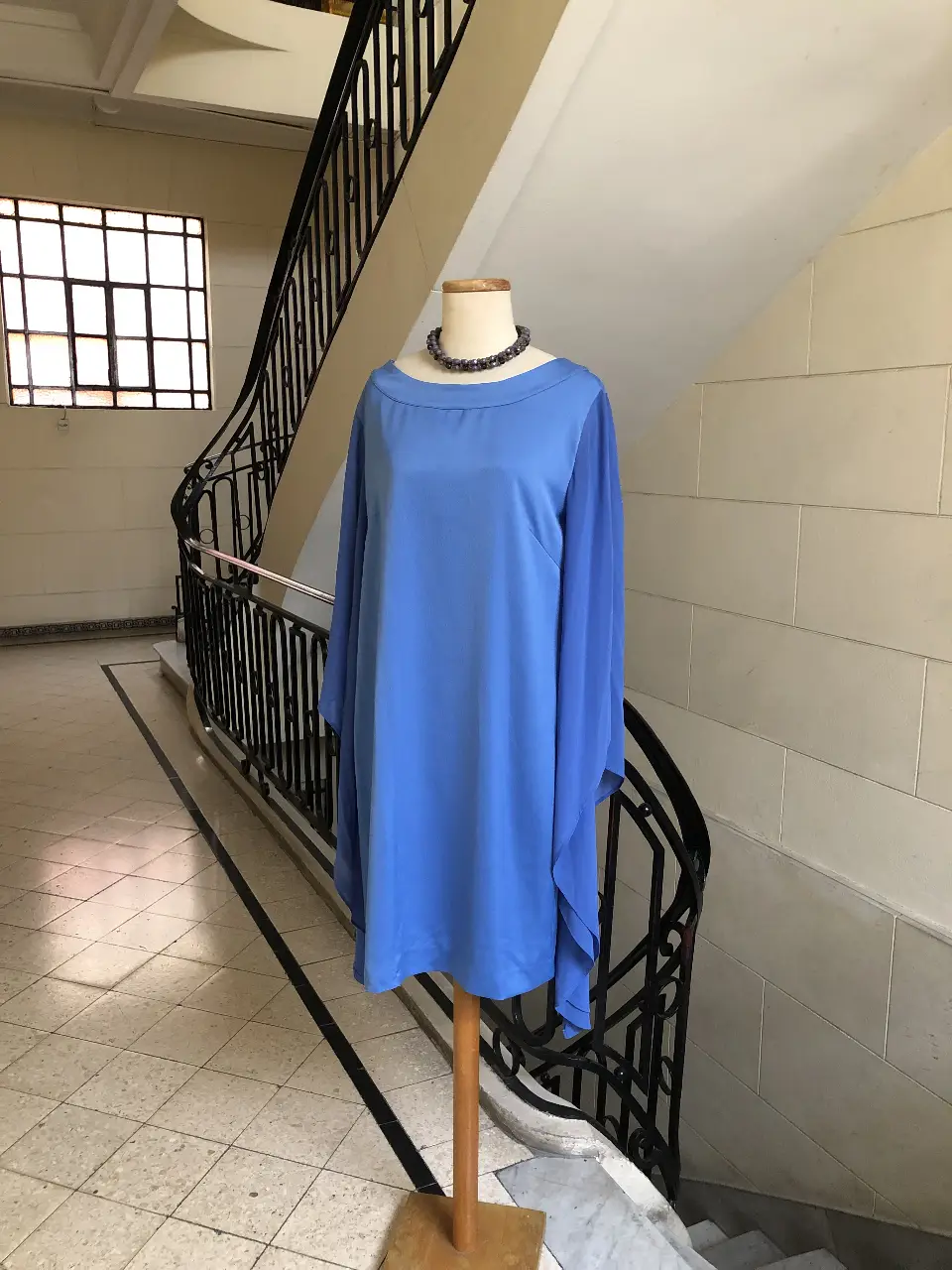 Vestido midi azul con mangas largas estilo capa. Ideal para eventos formales o fiestas. Diseño elegante y sofisticado.