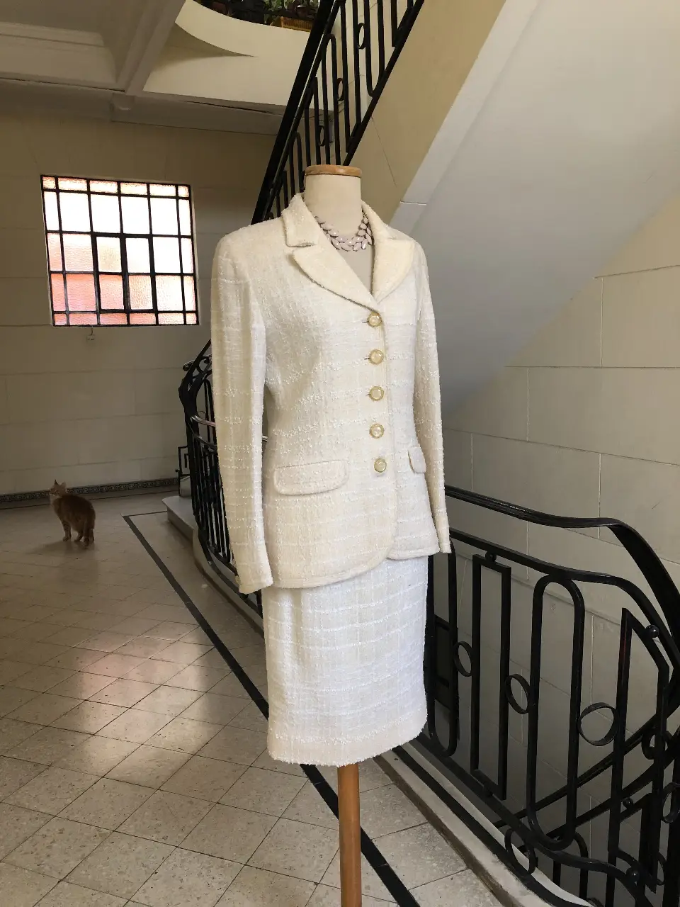 Elegante traje sastrero de dos piezas en color blanco. Incluye blazer con botones dorados y falda a juego. Ideal para eventos formales y looks sofisticados.