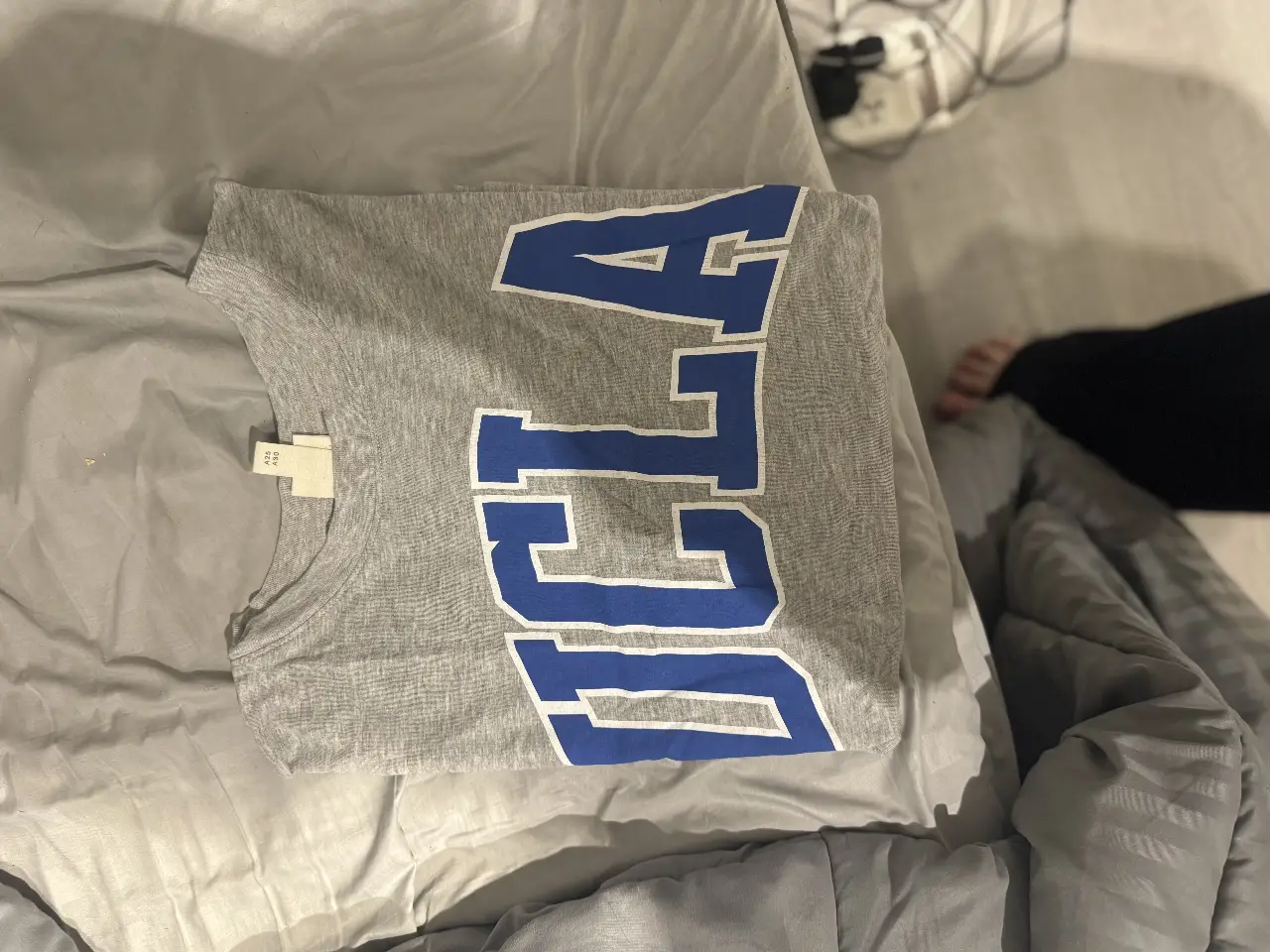 Remera de algodón gris con estampado de la universidad UCLA en color azul. Ideal para un look casual y deportivo.