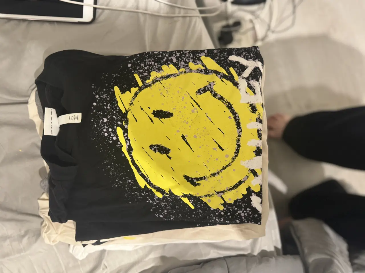 Remera negra con estampado de carita sonriente amarilla con detalles en blanco. Ideal para un look casual y con onda.