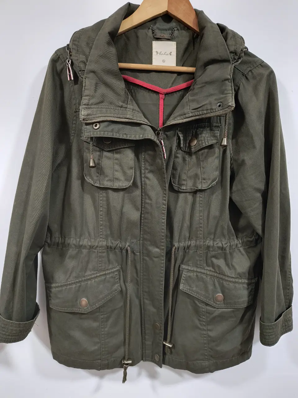 Campera verde militar con capucha y bolsillos. Ideal para un look casual y cómodo. Tiene cierre y ajuste en la cintura.
