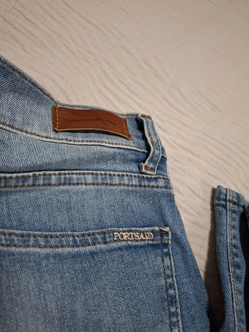 Jeans recto, color azul claro, con detalle de etiqueta de cuero en la parte trasera. Corte clásico y cómodo, ideal para uso diario.