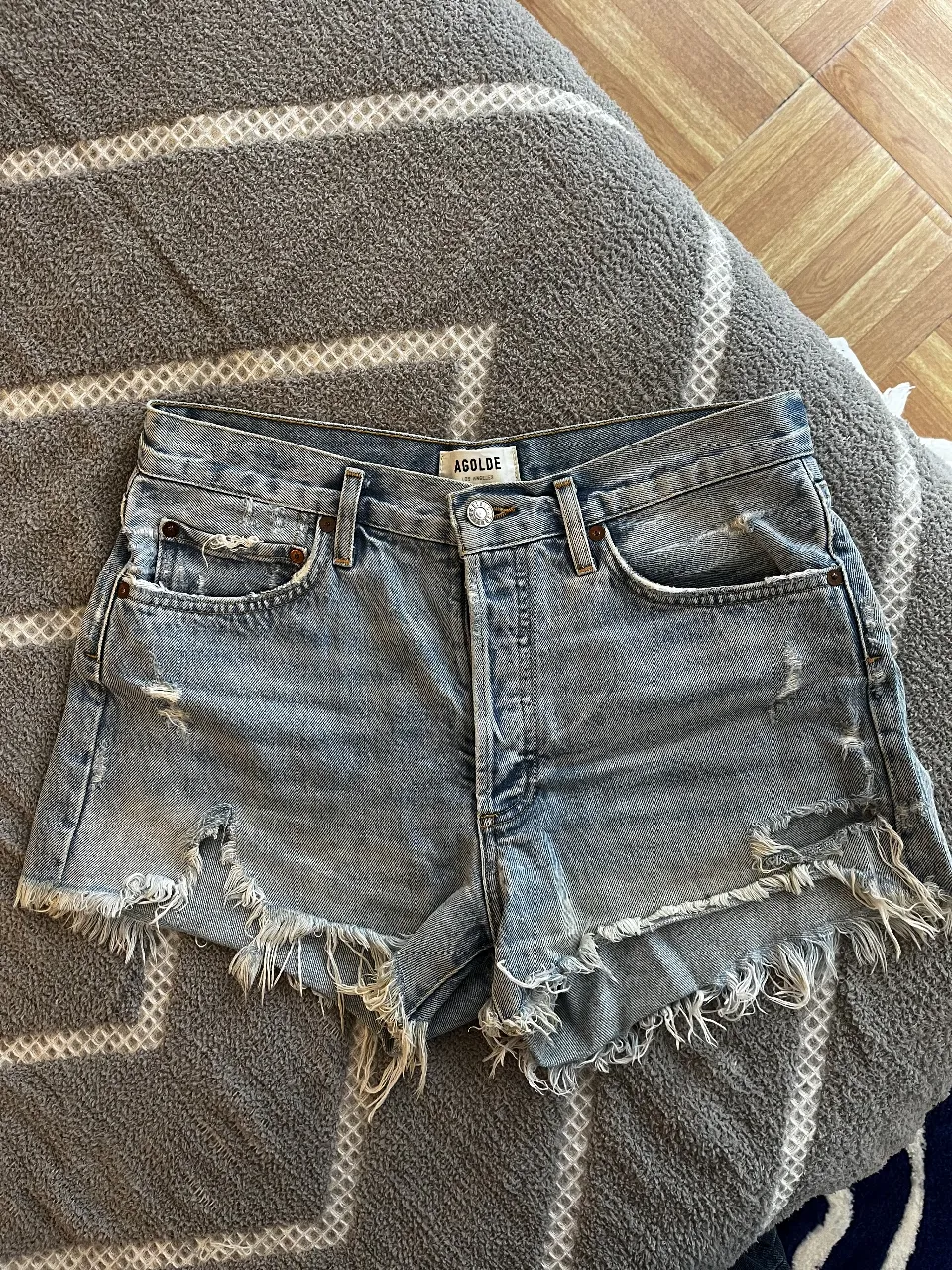 Short de jean de mujer, con detalles de roturas y flecos en el borde. Marca AGOLDE, talle 27.