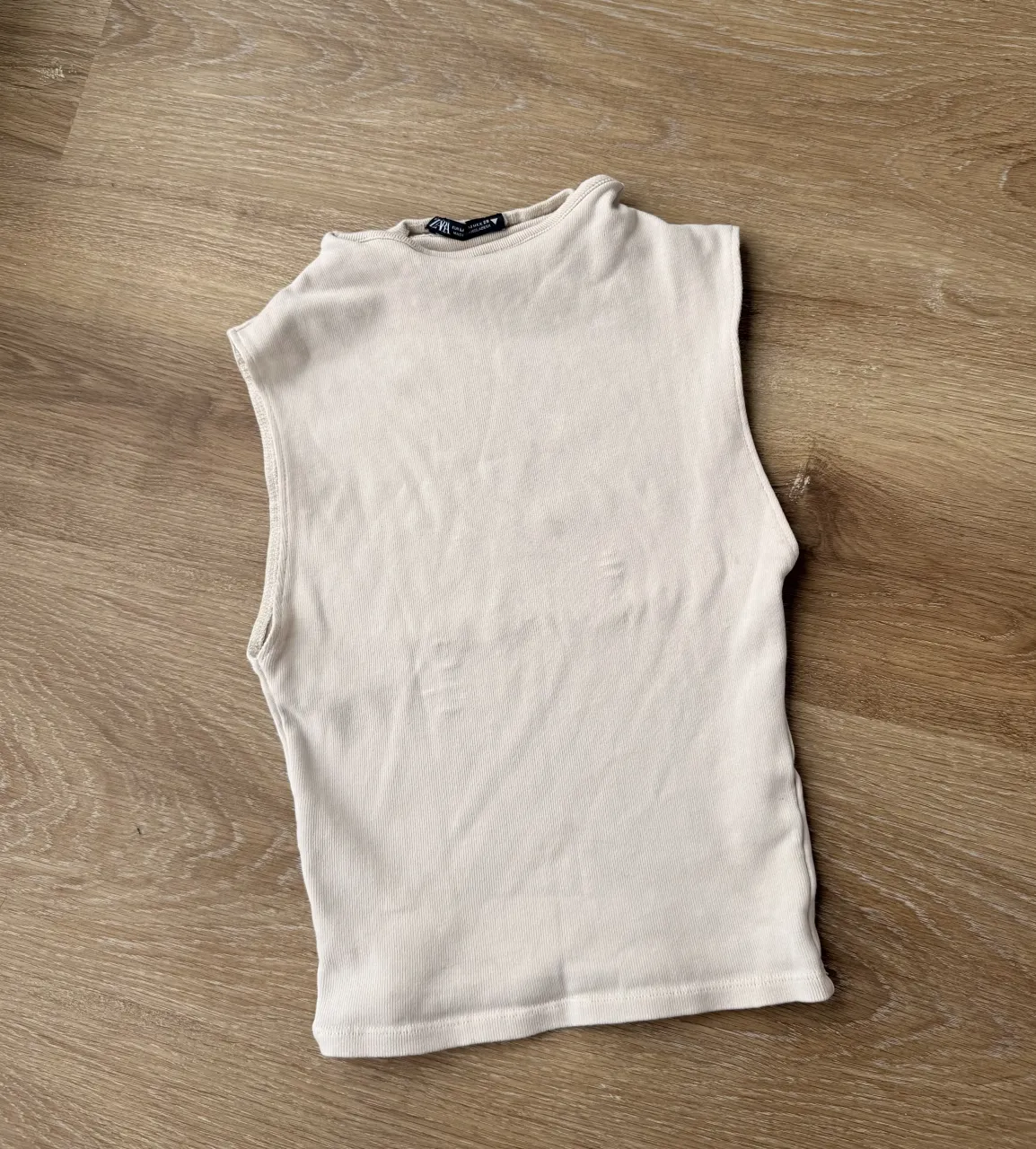 Musculosa con cuello tortuga de algodón acanalada color crudo. 