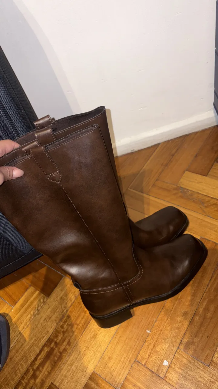 Botas de cuero marrones, caña alta, con punta cuadrada. Ideales para completar looks de invierno o entretiempo. Cierre interno para facilitar el calce.