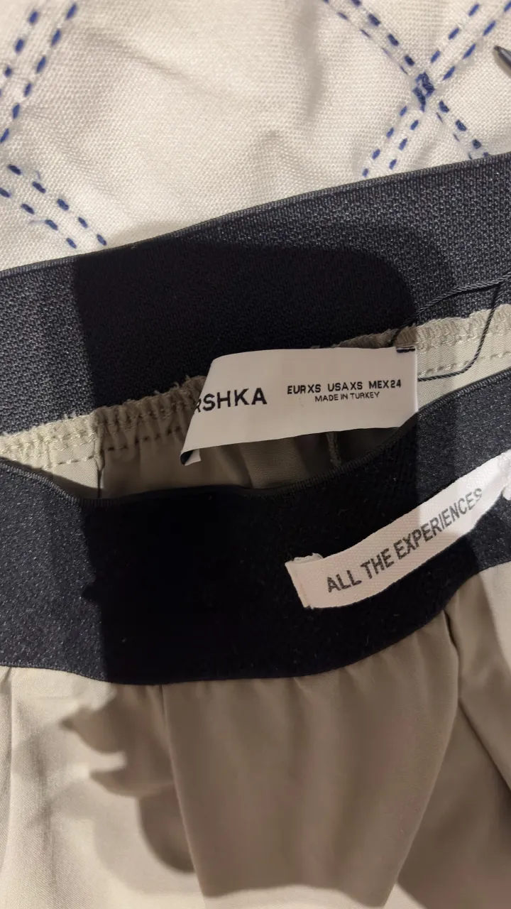 Pantalón de vestir color beige, tiro alto con elástico en la cintura. Corte recto y moderno, ideal para un look casual o para ir a trabajar. Confección de calidad y diseño minimalista.