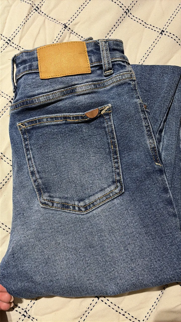 Jeans tiro alto con roturas y detalles desflecados en el bajo. Un clásico que no puede faltar en tu guardarropa, perfectos para un look casual y moderno.