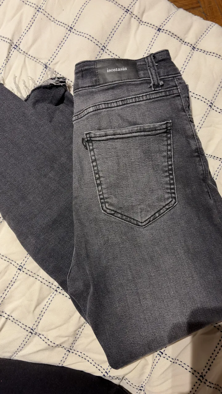 Jeans grises de corte recto, con un lavado desgastado y detalles desflecados en el bajo. Perfectos para un look casual y moderno.