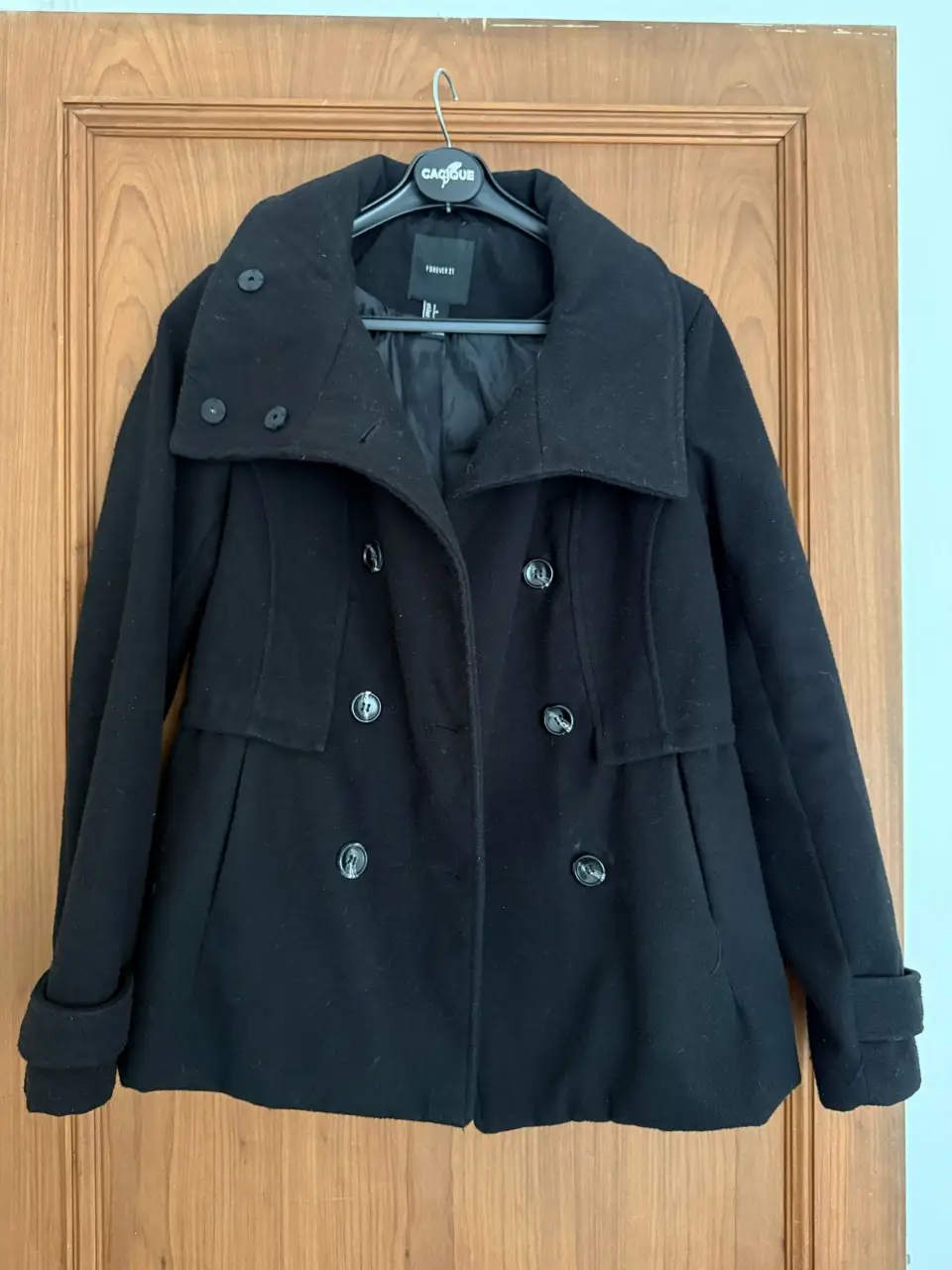 Tapado negro de paño, con cuello alto y botones. Ideal para el invierno, abrigo y estilo en una sola prenda. Perfecto para un look elegante y sofisticado.