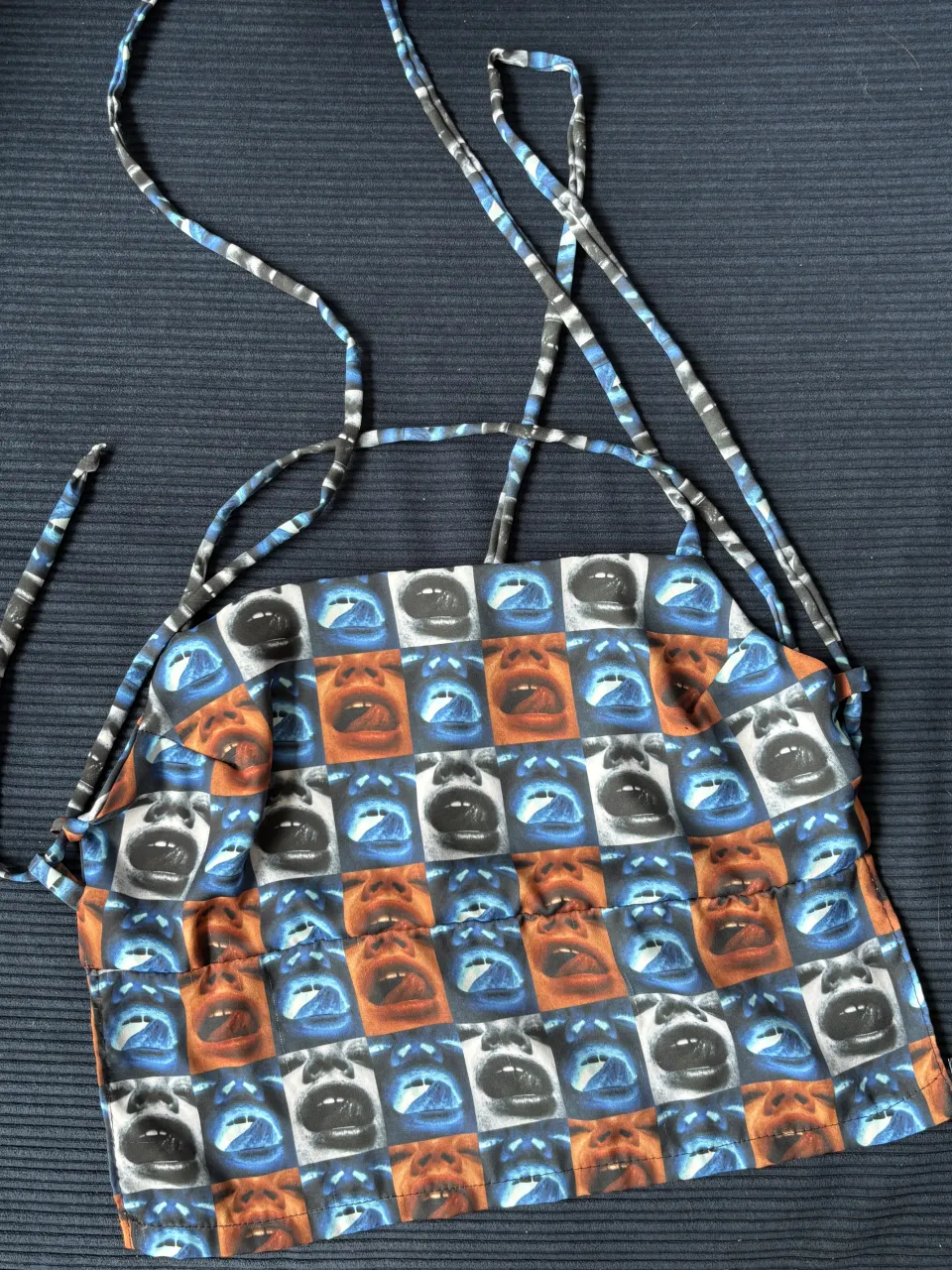 Top con estampa de caras y bocas. Breteles finos.