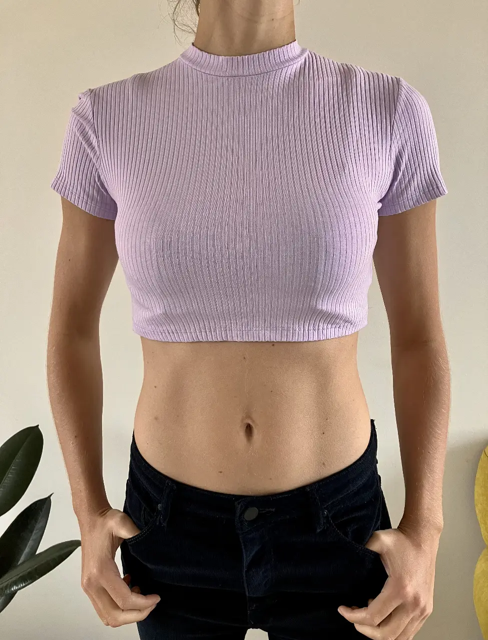 Top corto de cuello alto en color lila, ideal para un look casual y moderno. Confeccionado en tejido de punto acanalado, este top es perfecto para combinar con jeans de tiro alto o pantalones de cintura baja.