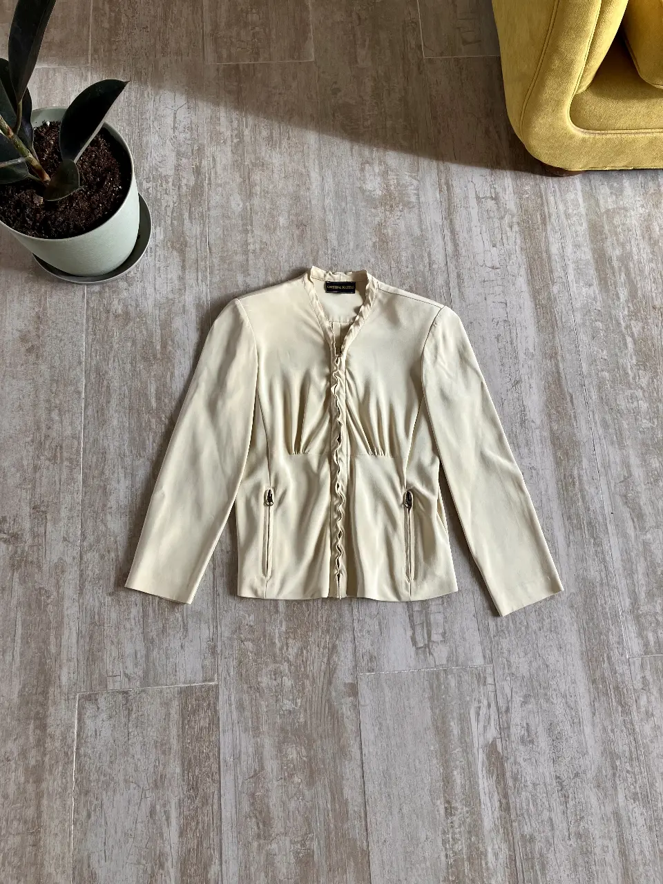 Blazer de mujer color crudo, con cierre y detalles de volantes en el frente. Talle 44. Ideal para un look elegante y sofisticado.