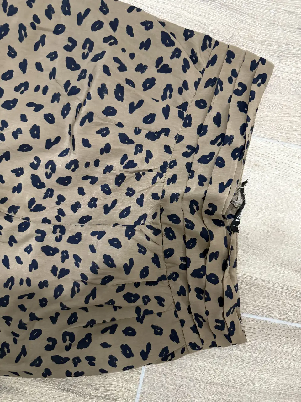 Short de tela con estampado de leopardo en tonos marrones y detalles en azul. Ideal para un look casual y moderno.