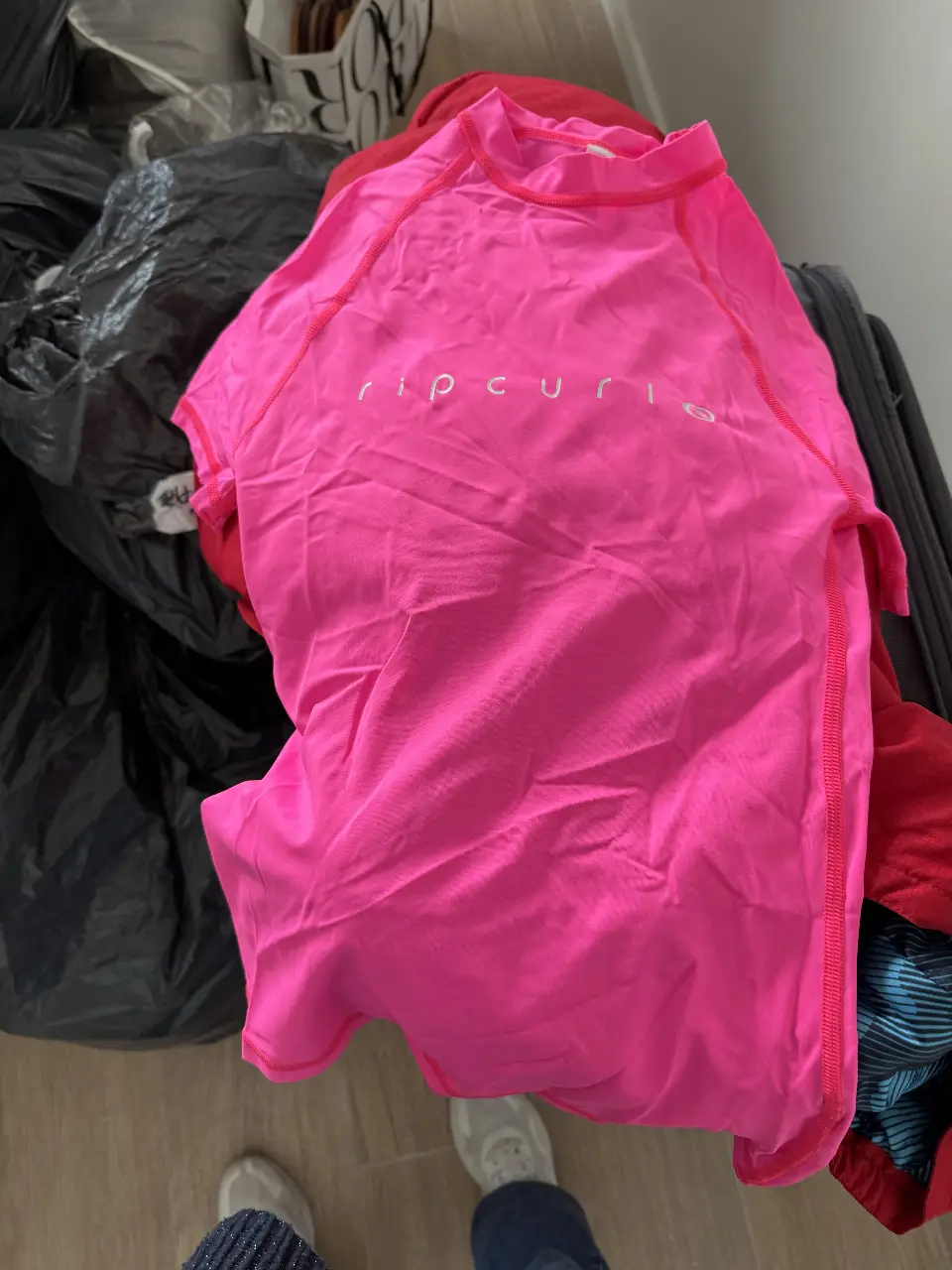 Remera deportiva de manga corta para mujer, color rosa, con logo de la marca Rip Curl en el frente. Ideal para actividades acuáticas o deportes al aire libre.